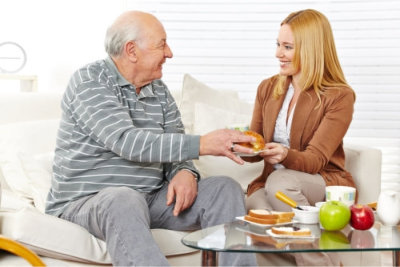 elderly man with his caregiver eating a breakfast together